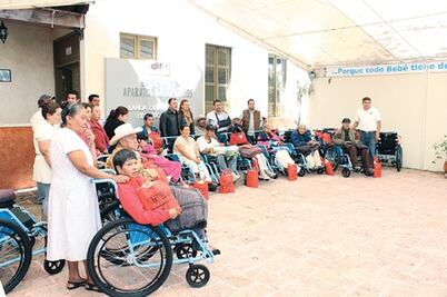 Ayudan a adultos con sillas de rueda