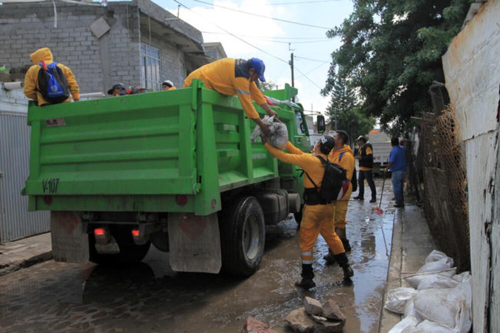 Afectados por el desborde de aguas negras, los vecinos tuvieron que colocar costales para impedir que el líquido ingresara a sus hogares. Protección Civil acudió a ayudar a los habitantes de la calle Adolfo López Mateos. (CESAR GÓMEZ. EL UNIVERSAL)