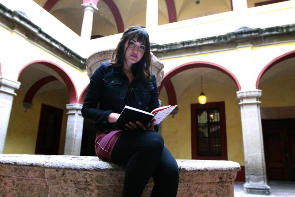 Tania Limas López Velarde se presenta con la gente que quiera escucharla, les ofrece separadores de libros con un poema de su autoría atrás del mismo