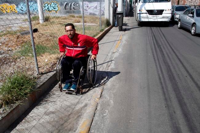Óscar Gómez recorre la ciudad en su silla de ruedas, algunos transportistas lo ayudan a subirse a la unidad, otros solo miran / Fotos: Guillermo González