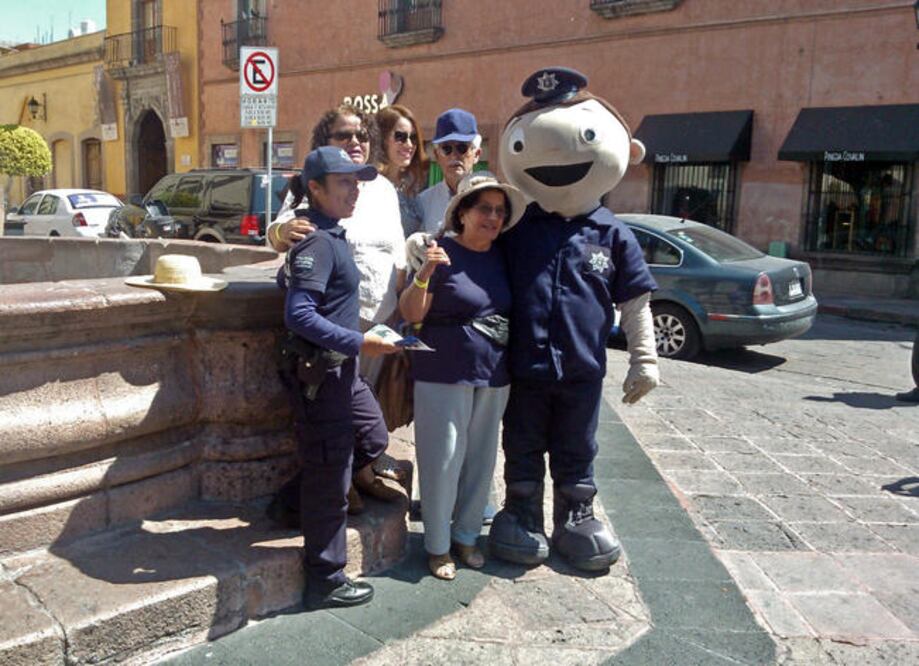 Turistas se toman una foto con la “polibotarga”, personaje que forma parte de la estrategia de seguridad implementada para estas vacaciones. (DOMINGO VALDEZ. EL UNIVERSAL)