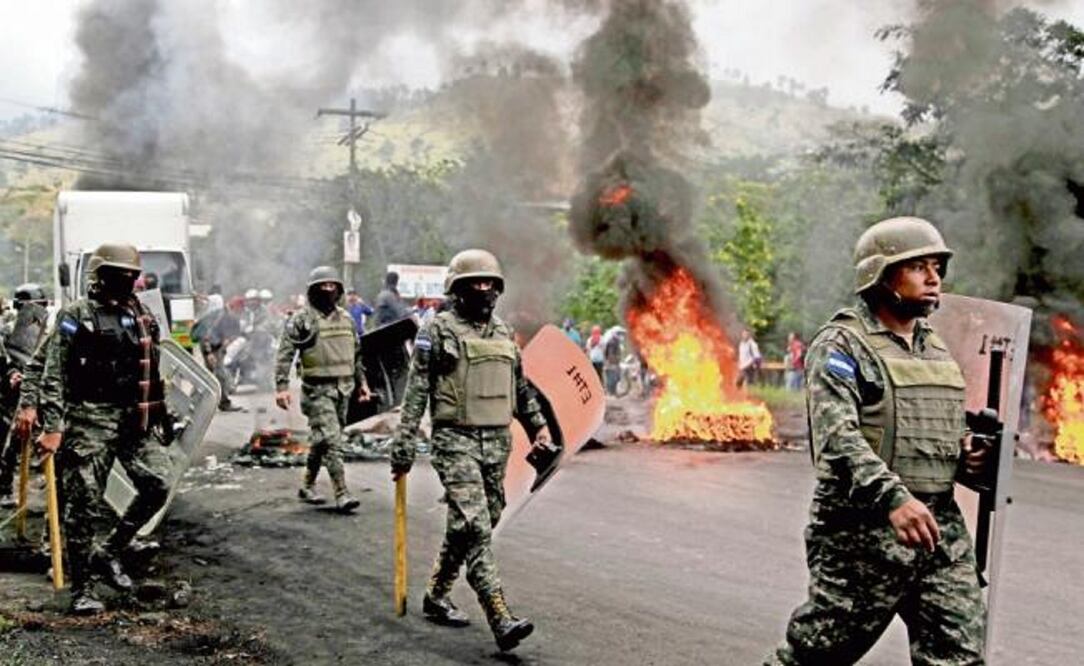 Soldados cruzaron una barricada de simpatizantes de la oposición en Honduras, uno de los países donde la militarización en las calles lleva casi 10 años. (FERNANDO ANTONIO. AP)