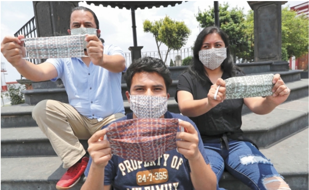Familiares y amigos del artesano Jesús Zarate muestran los cubrebocas elaborados con telar de cintura y los cuales venden en el municipio de Toluca, en el Estado de México.