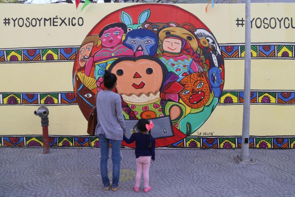 En la parte central de la pintura se observa a Xanhi tomándose una foto grupal con un caballito de madera, una muñeca de cartón, un luchador y también aparecen otros elementos muy mexicanos. (FOTOS: GONZALO IBÁÑEZ. EL UNIVERSAL)