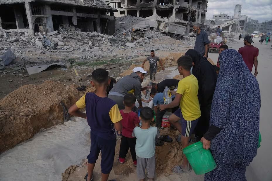 Palestinos recolectan agua, aprovechando el cese el fuego declarado entre Israel y Hamas, en Ciudad de Gaza. FOTO: JEHAD ALSHRAFI
