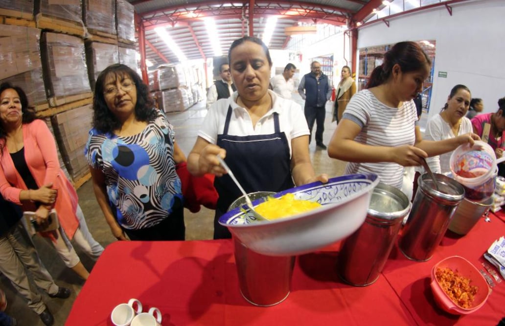 Las dos jóvenes que brindan la capacitación explican que deben mover muy bien el recipiente con la nieve, para mezclar bien los ingredientes, así como para evitar que se pegue a las paredes del mismo.