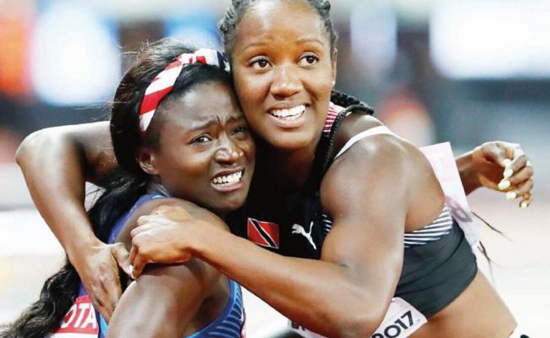 Tori Bowie, de EU y Kelly-Ann Baptiste, de TyT se abrazan al ver el resultado. (LUCY NICHOLSON. REUTERS)