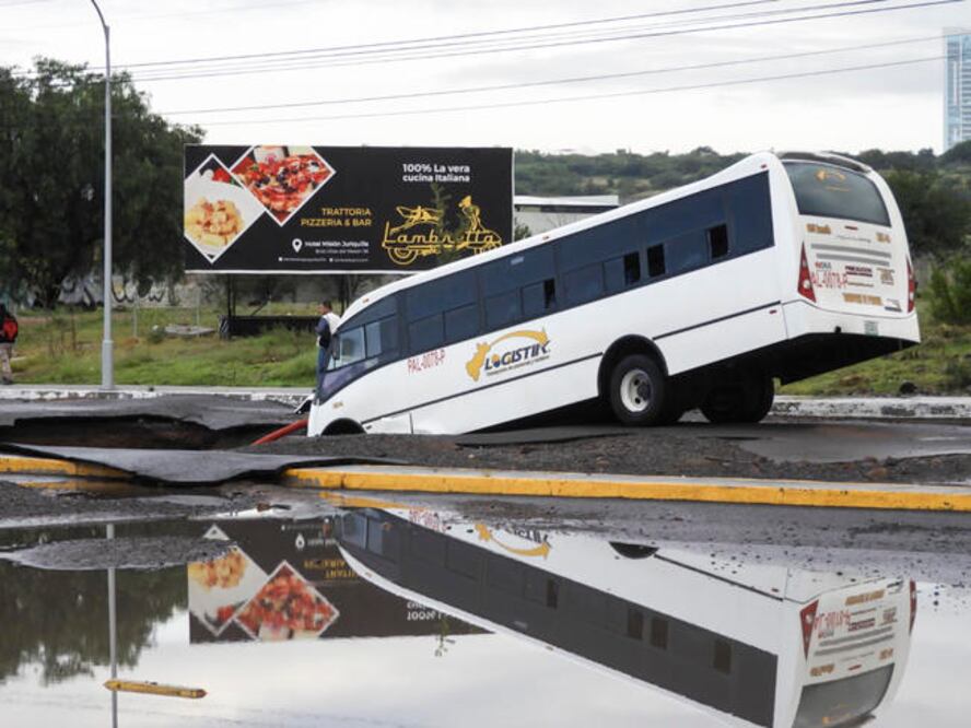 La imagen del autobús hundido en la tierra comenzó a circular en redes sociales desde temprano; el agujero en la tierra va de lado a lado de la calle impidiendo el paso de habitantes y carros al pueblo de Jurica. (RAFAEL VIGIL. EL UNIVERSAL)
