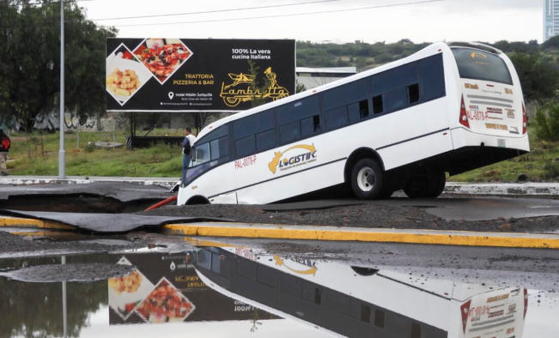 La imagen del autobús hundido en la tierra comenzó a circular en redes sociales desde temprano; el agujero en la tierra va de lado a lado de la calle impidiendo el paso de habitantes y carros al pueblo de Jurica. (RAFAEL VIGIL. EL UNIVERSAL)