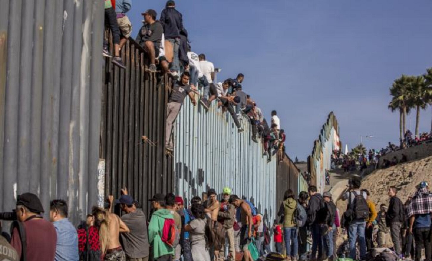 Algunos migrantes treparon el muro fronterizo y ante los agentes de EU que custodian la zona gritaron: “¡No somos delincuentes!”. (JOEBETH TERRÍQUEZ. EL UNIVERSAL)