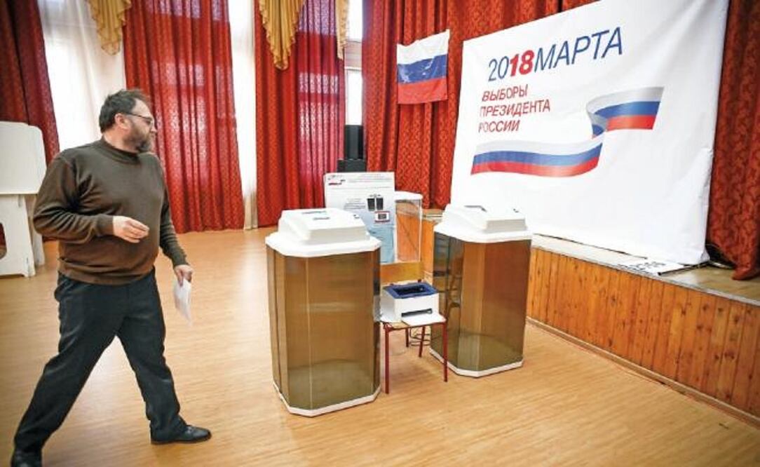Miembros de la comisión de elección local preparaban ayer las máquinas de votación en una de las casillas instaladas para los comicios de hoy (ALEXANDER NEMENOV. AFP)