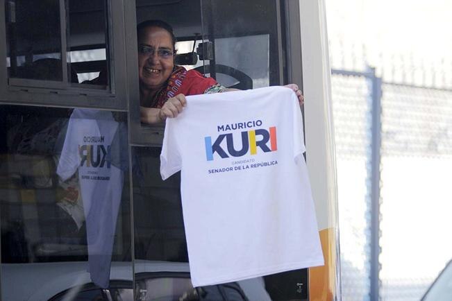 Durante su primer día de campaña rumbo al Senado, Mauricio Kuri, candidato de la coalición Por México al Frente, recibe saludos de una seguidora desde un autobús urbano, en Zaragoza y Constituyentes. Foto: Mario Valdés