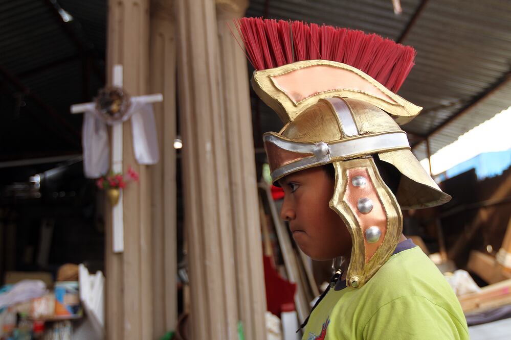Entre los ayudantes para la escenificación de la Pasión, se encuentra un niño de 10 años de edad, quien ayuda a pintar los cascos de los centuriones romanos que habrán de apresar a Jesús la noche del jueves (LUIS SÁNCHEZ)
