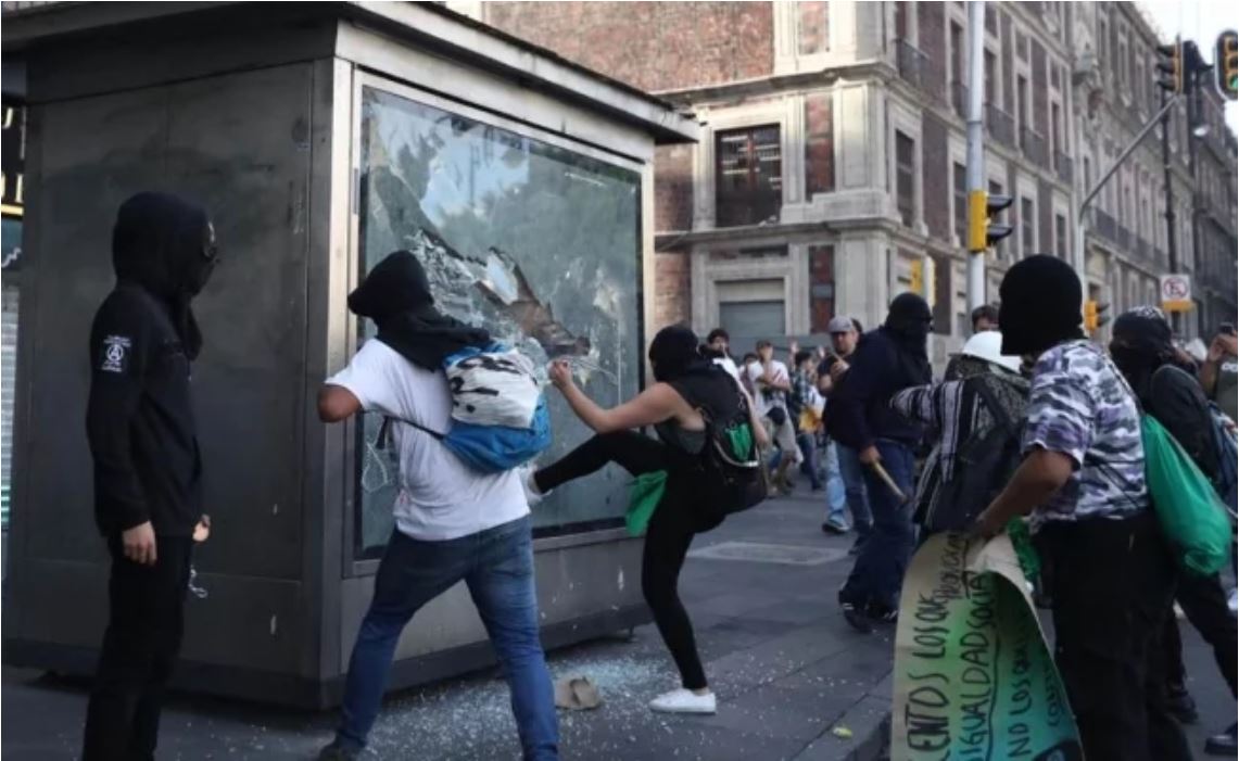 Embozados pintan edificios públicos y lanzan cohetón en marcha por 2 de Octubre