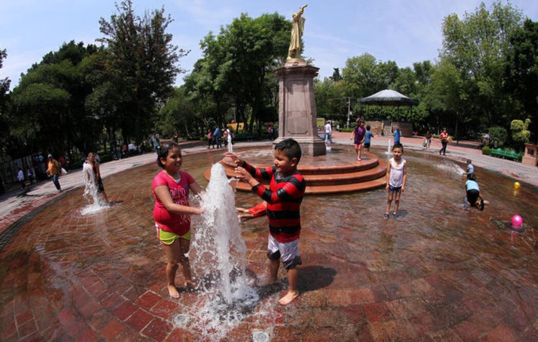 Los niños esperan con ansia quitarse las playeras e ir a mojarse en las fuentes del lugar. Sus padres los miran de lejos con una sonrisa en el rostro. Ninguno de los pequeños puede resistirse a quitarse el calor en los vibrantes chorros de agua. (LUIS S.)