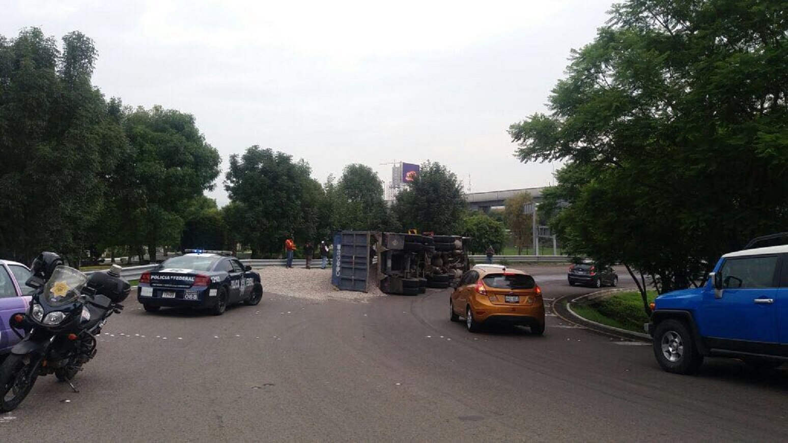 Vuelca y riega gravilla en trébol de la Cuota y Constituyentes 