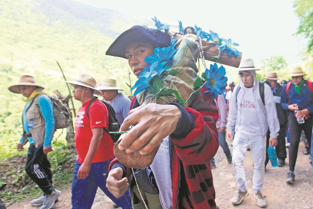 Los hombres, con sus sombreros color beige, algunos apoyados con bastones y cayados (bastón grueso de madera)  avanzan por la terracería que lleva a la salida de la comunidad de Neblinas.