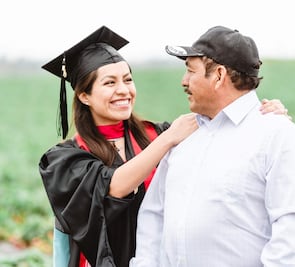 Celebra graduación con fotos en el campo donde trabajan sus padres migrantes