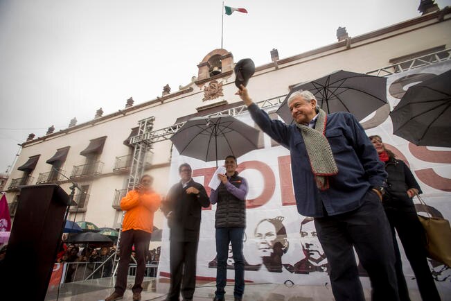 Lluvia intensa y miles de personas reciben a AMLO