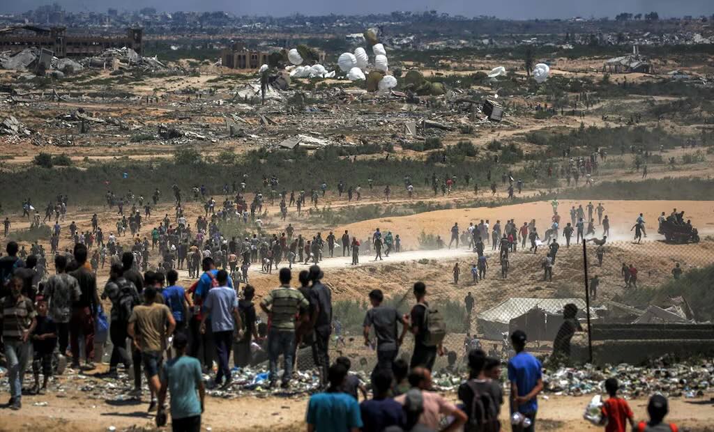 Palestinos acuden a recolectar ayuda humanitaria lanzada desde el aire sobre Nuseirat, en el centro de la Franja de Gaza. Foto: AFP