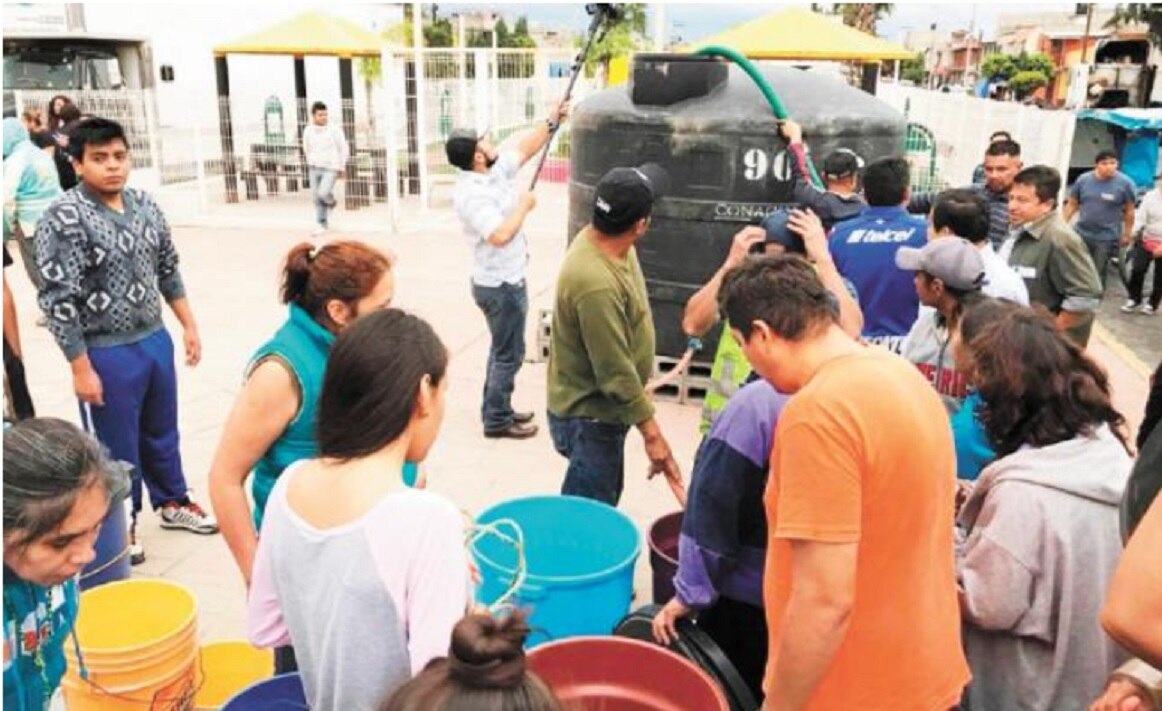 Contenedores con agua fueron colocados en la vía pública para que los residentes se abastezcan durante la contingencia. Foto: ESPECIAL