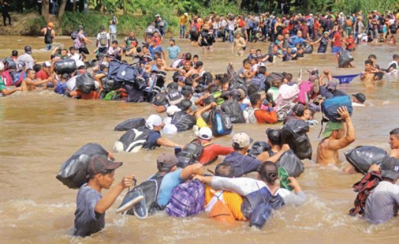 Caravana migrante cruza caminando el río Suchiate