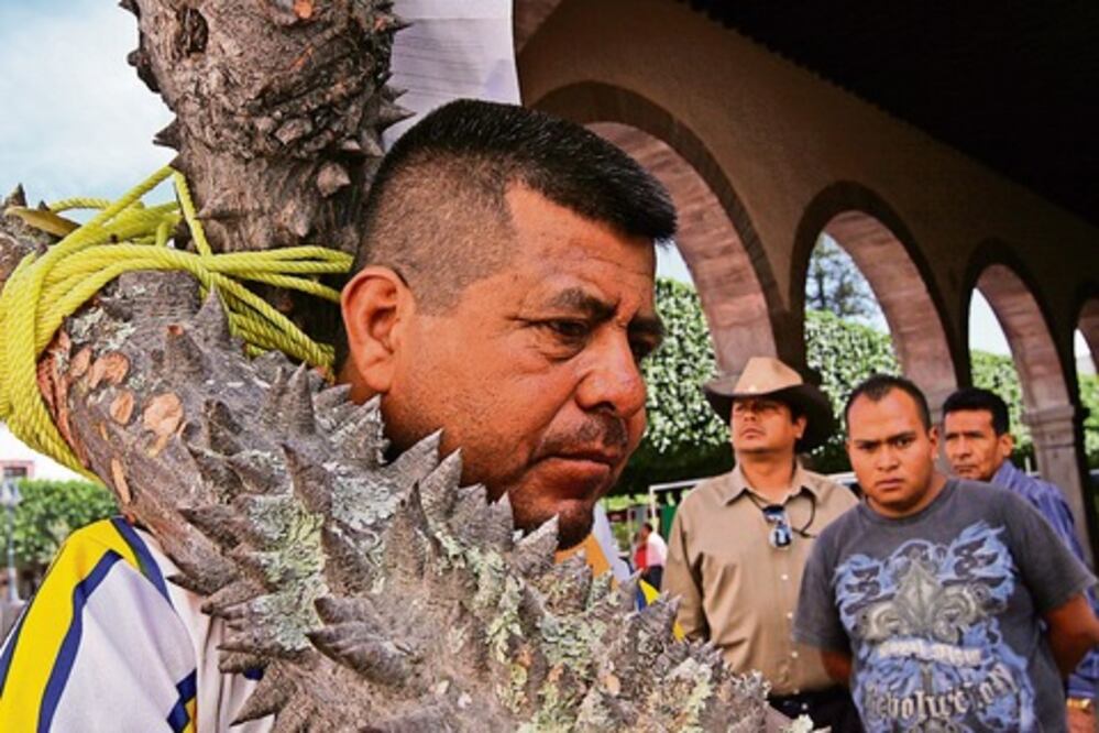 Con una cruz a cuestas, pide justicia