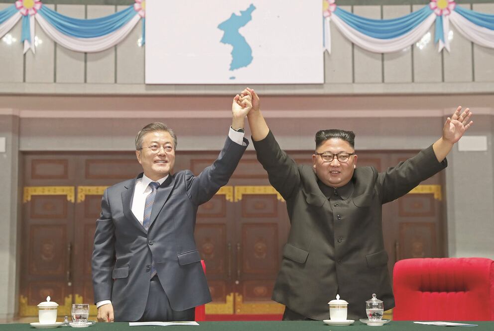 El presidente de Corea del Sur, Moon Jae-in, y el líder norcoreano, Kim Jong-un, levantan sus manos tras un evento deportivo en un estadio de Pyongyang. (AP)