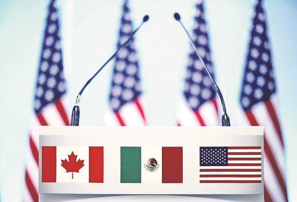 Banderas de los tres países del TLCAN en un atril antes de la conferencia que cerraba la séptima ronda en la Ciudad de México. FOTO: ARCHIVO