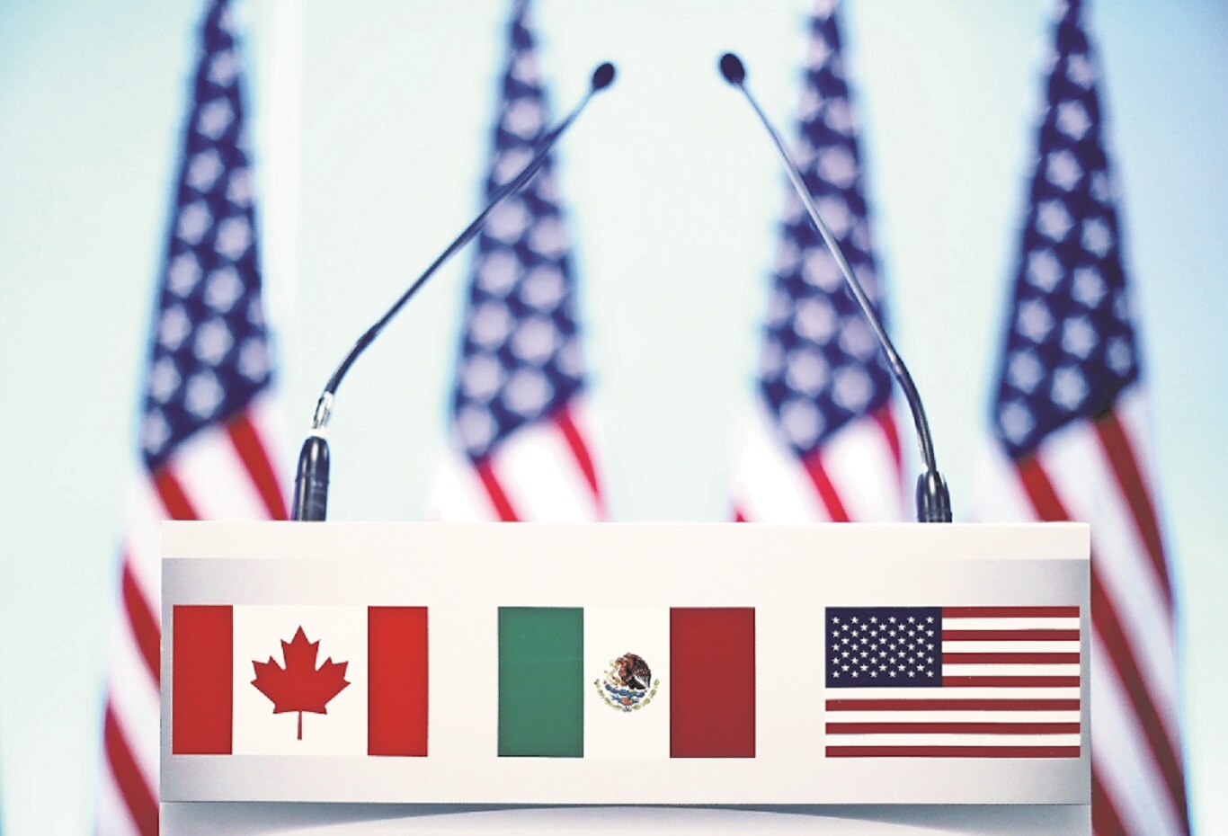 Banderas de los tres países del TLCAN en un atril antes de la conferencia que cerraba la séptima ronda en la Ciudad de México. FOTO: ARCHIVO
