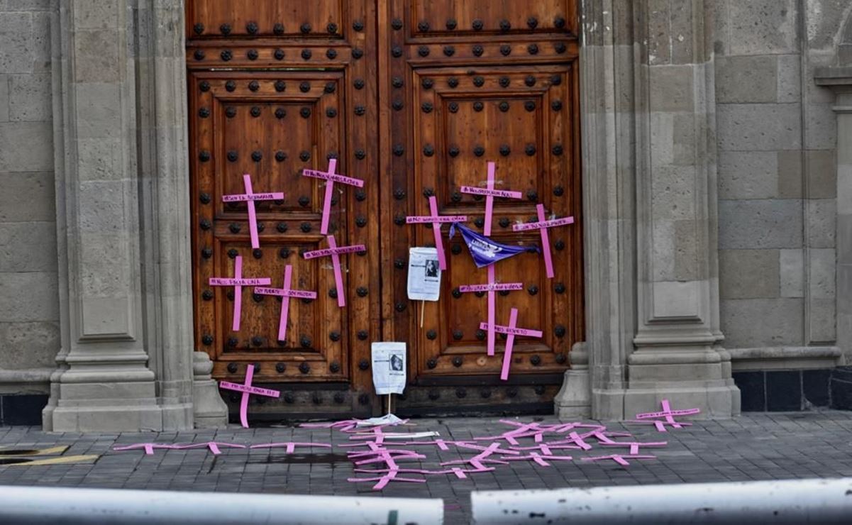 Mujeres saltan valla de Palacio Nacional y colocan cruces en protesta contra feminicidios